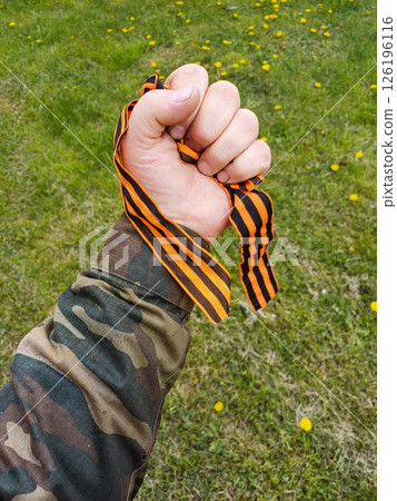 St. George's ribbon in the hand of a soldier. 126196116