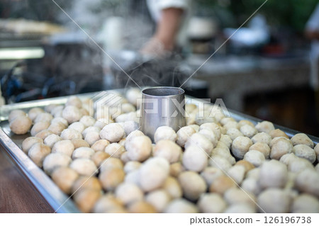 Pork meatballs steam and grill on portable stove at street food vendor cooking stall. Thai market Pork meatballs steam and grill on portable stove at street food vendor cooking stall. Thai market 126196738
