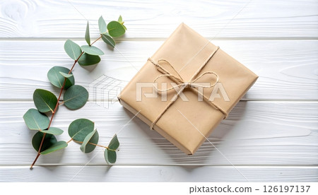 Rustic Paper Gift with Eucalyptus Sprig on White Wood Rustic Paper Gift with Eucalyptus Sprig on White Wood 126197137
