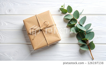 Rustic Paper Gift with Eucalyptus Sprig on White Wood Rustic Paper Gift with Eucalyptus Sprig on White Wood 126197138