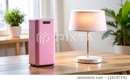 Pink wireless speaker and table lamp on wooden table Pink wireless speaker and table lamp on wooden table 126197543