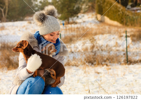 Woman playing with dogs during winter 126197822