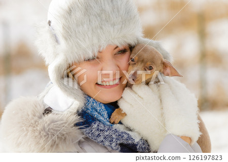 Woman playing with dog during winter Woman playing with dog during winter 126197823