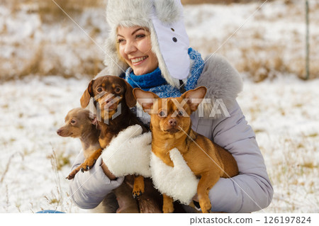 Woman playing with dogs during winter Woman playing with dogs during winter 126197824