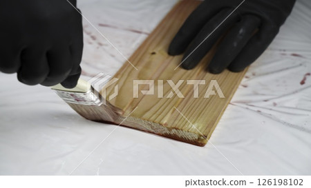 Meticulously Painting a Wooden Surface with Careful Attention to Detail and Protection. Creative Meticulously Painting a Wooden Surface with Careful Attention to Detail and Protection. Creative 126198102