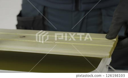 A tutorial shows treating wood with a yellow liquid, ensuring even coverage. Creative A tutorial shows treating wood with a yellow liquid, ensuring even coverage. Creative 126198103