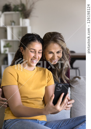 Friendly senior mom daughter teenager shooting family selfie on smartphone 126198124