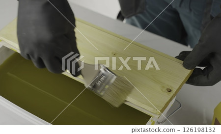 An artisan paints wood, cleans honeycomb, showcasing dedication. Creative An artisan paints wood, cleans honeycomb, showcasing dedication. Creative 126198132