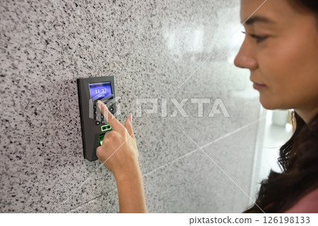 Closeup young woman pressing buttons on smart electronic alarm system 126198133