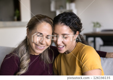 Affectionate aged mom teen daughter touching heads with closed eyes Affectionate aged mom teen daughter touching heads with closed eyes 126198135