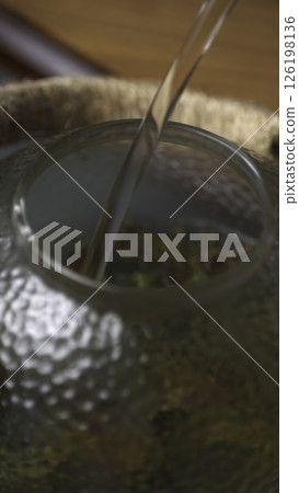 Gently pouring water into a beautifully designed glass teapot creates a serene ambiance. Media Gently pouring water into a beautifully designed glass teapot creates a serene ambiance. Media 126198136