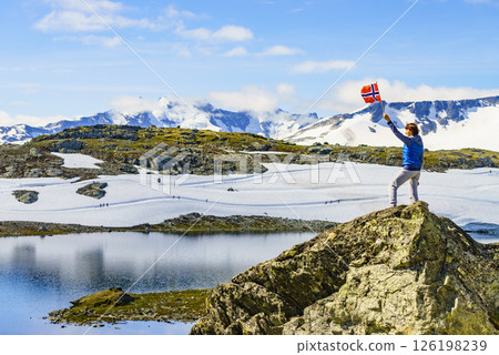 Tourist with norwegian flag in mountains 126198239