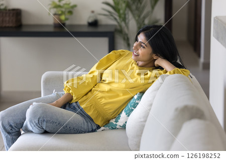 Relaxed carefree young woman rest on comfy couch at home 126198252