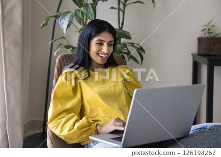 Happy young female enjoy home office comfort typing on notebook Happy young female enjoy home office comfort typing on notebook 126198267