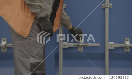 Worker closing a door to the production container. Stock Footage Worker closing a door to the production container. Stock Footage 126198312