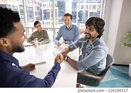 Two partners shaking hands during meeting event in conference room 126198317