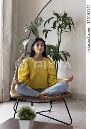 Millennial woman relax by meditation sit on chair cross legged 126198321