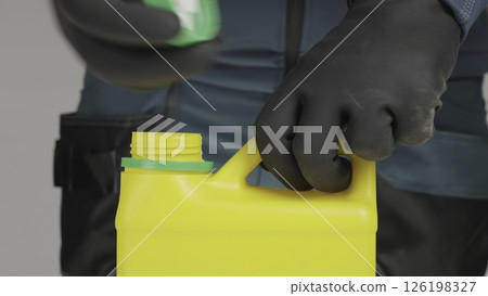 A man's hand closes a yellow bottle. Creative 126198327