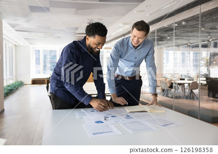 Two young professional teammates analyzing business data Two young professional teammates analyzing business data 126198358