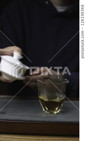 The Detailed Tea Brewing Process Using a Gaiwan and a Glass Cup for Enjoyment and Wellness. Media 126198368