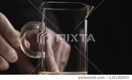 A Hand Holding a Transparent Glass Mug That Contains Liquid Drink Creatively Displayed. Media A Hand Holding a Transparent Glass Mug That Contains Liquid Drink Creatively Displayed. Media 126198403