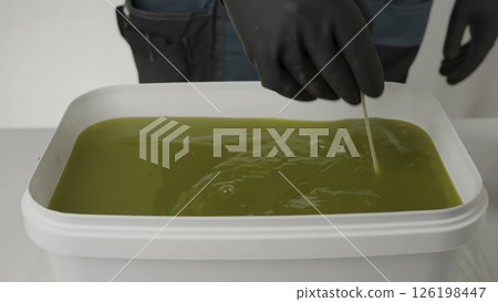A person handles vibrant green liquid in various ways. Creative A person handles vibrant green liquid in various ways. Creative 126198447
