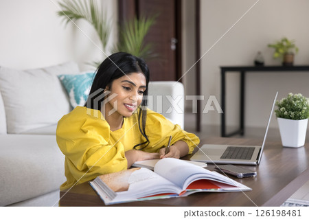 Millennial girl student use books notebook to study at home 126198481