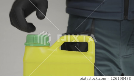 A man opens a yellow container with a green lid, revealing its contents. Creative 126198488