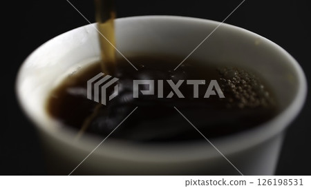 Pouring a steaming hot beverage into a delicate white cup enhances the overall experience. Media 126198531