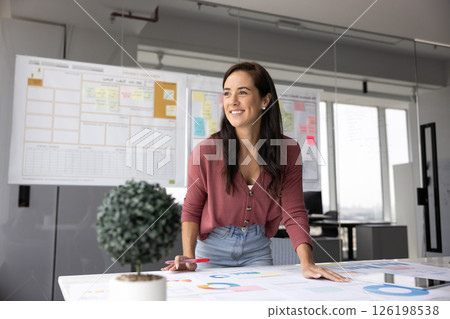 Happy young woman distracted from data analysis with smile Happy young woman distracted from data analysis with smile 126198538