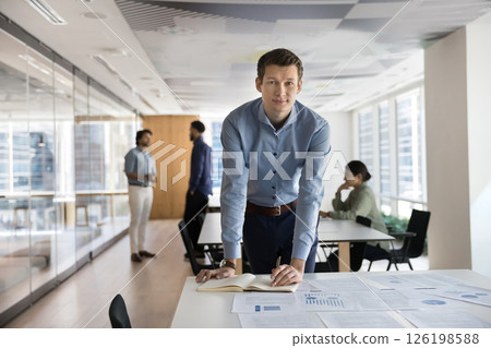 Portrait of young man, project manager reviewing documentation 126198588