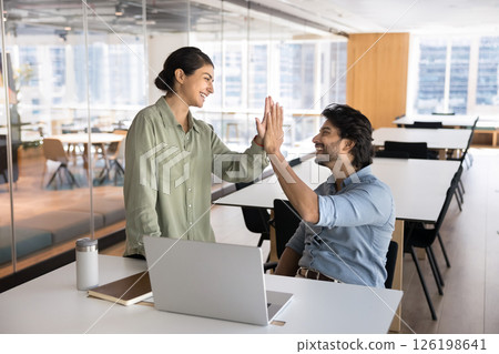 Two happy Indian employees giving high five during meeting Two happy Indian employees giving high five during meeting 126198641