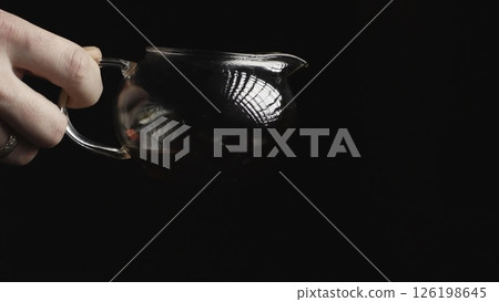 An elegant and captivating pour of a rich, dark liquid into a wellcrafted glass jug. Media An elegant and captivating pour of a rich, dark liquid into a wellcrafted glass jug. Media 126198645