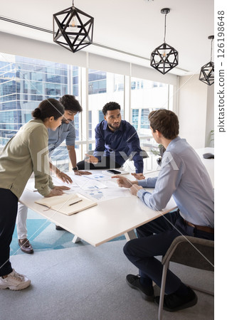 Team analyzing market trends gathered together in modern meeting room Team analyzing market trends gathered together in modern meeting room 126198648