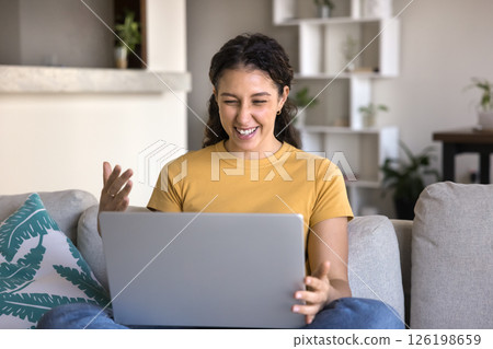 Excited teen girl sit on couch hold notebook feel triumph Excited teen girl sit on couch hold notebook feel triumph 126198659