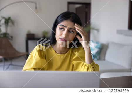 Sad confused young woman look aside of notebook screen 126198759