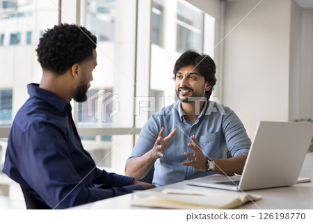 The businessmen engaged in formal discussion met in office boardroom 126198770