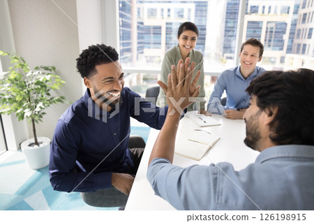 Two business professionals enthusiastically exchange high-five gesture Two business professionals enthusiastically exchange high-five gesture 126198915