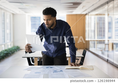 Focused African professional engaged in data analysis and decision-making 126198944