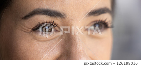Cropped closeup smiling young female with dark eyes looking aside 126199016