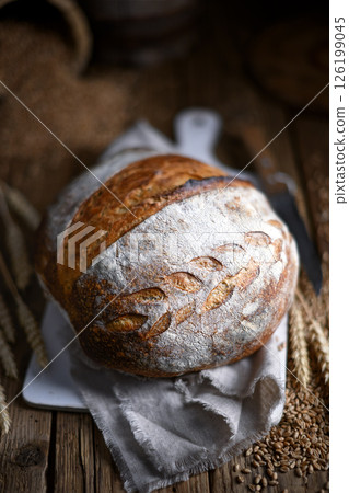 Browned crusty sourdough bread with cracked top Browned crusty sourdough bread with cracked top 126199045