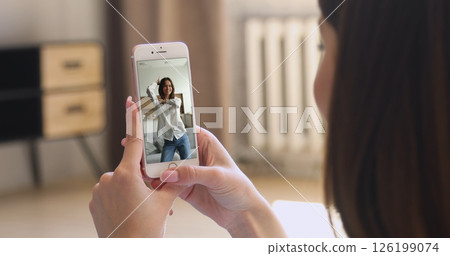 Close up of female holding modern smartphone watching internet content 126199074