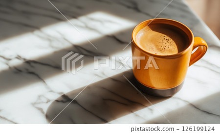 Warm cup of coffee on a sunlit marble table 126199124