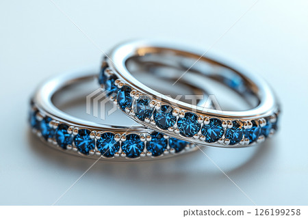 Luxurious pair of wedding rings with blue stones on a white background. Rococo-Renaissance style. Luxurious pair of wedding rings with blue stones on a white background. Rococo-Renaissance style. 126199258