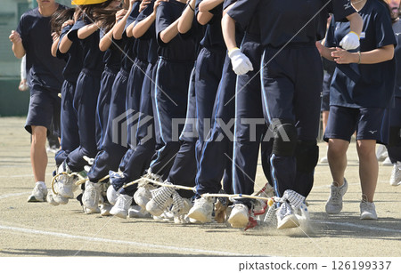 People participating in a centipede race at a sports festival People participating in a centipede race at a sports festival 126199337