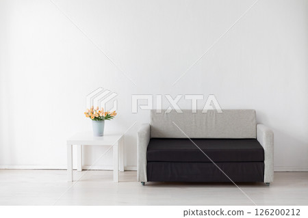 office sofa with flowers and gifts in the interior of a white room 126200212