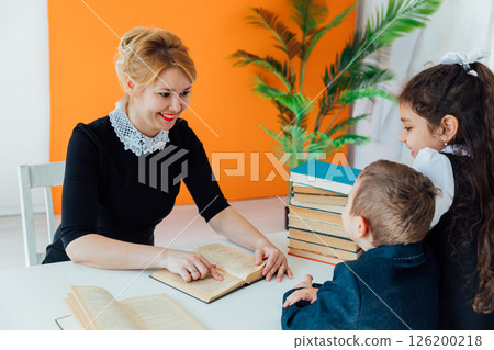 Teacher Conducting Lesson with Book for Children in School Teacher Conducting Lesson with Book for Children in School 126200218