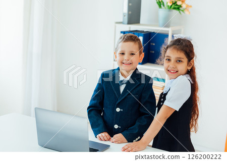 Girl And Boy Schoolchildren Do Homework At Table With Laptop 126200222