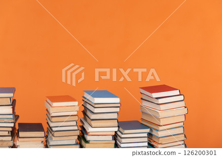 Stacks of old books for learning on an orange background Stacks of old books for learning on an orange background 126200301
