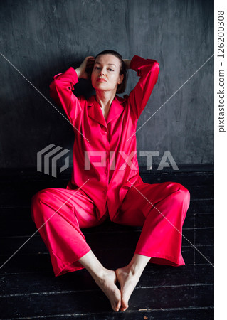 40 year old woman in pajamas sitting on the floor 40 year old woman in pajamas sitting on the floor 126200308